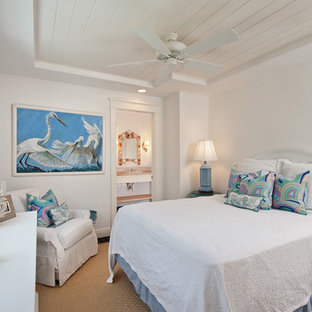 Bedroom - tropical guest medium tone wood floor bedroom idea in Miami with white walls