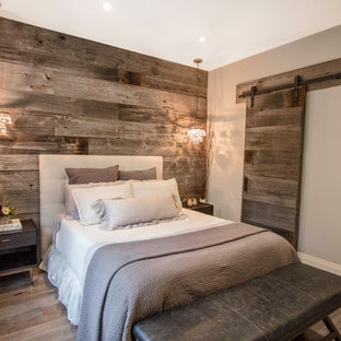 Ejemplo de dormitorio campestre con paredes grises, suelo de madera en tonos medios y suelo gris