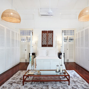 Design ideas for a large world-inspired bedroom with white walls, medium hardwood flooring and brown floors.