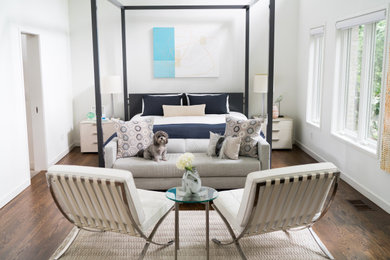 Example of a large minimalist master medium tone wood floor and brown floor bedroom design in Dallas with white walls and no fireplace