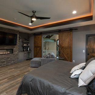 Photo of a mid-sized traditional master bedroom in Detroit with grey walls, marble floors, a ribbon fireplace, a stone fireplace surround and multi-coloured floor.
