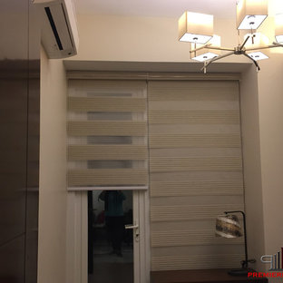 Imagen de dormitorio principal, contemporáneo, de tamaño medio, con paredes blancas, suelo laminado y suelo amarillo