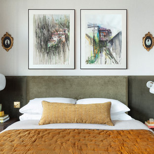 Design ideas for a contemporary bedroom in London with white walls, medium hardwood flooring and brown floors.