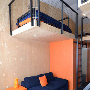 Immagine di una camera da letto stile loft design con pareti arancioni