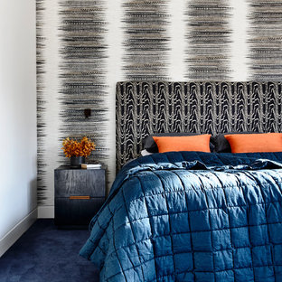 Idée de décoration pour une très grand chambre avec moquette design avec un mur multicolore et un sol bleu.