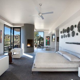 Großes Modernes Hauptschlafzimmer mit weißer Wandfarbe, Eckkamin und Kaminumrandung aus Beton in Phoenix