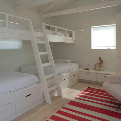 Example of a trendy guest light wood floor bedroom design in Austin with white walls and no fireplace