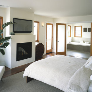 Modernes Schlafzimmer mit beiger Wandfarbe, braunem Holzboden und Kamin in San Francisco