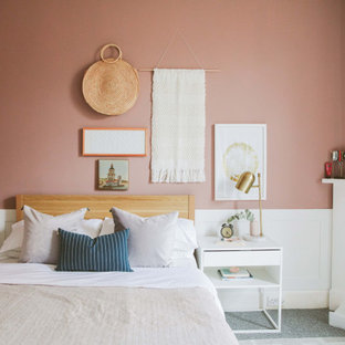 Imagen de dormitorio principal, contemporáneo, de tamaño medio, con parades naranjas, moqueta, chimenea tradicional, marco de chimenea de baldosas y/o azulejos y suelo gris