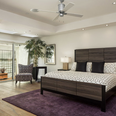 Trendy master light wood floor bedroom photo in Other with white walls