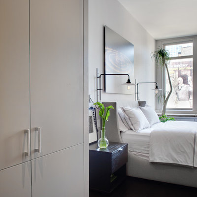 Bedroom - contemporary dark wood floor bedroom idea in New York with white walls