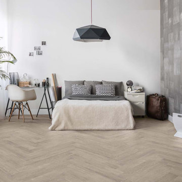 Contemporary bedroom with light herringbone wood look porcelain floors