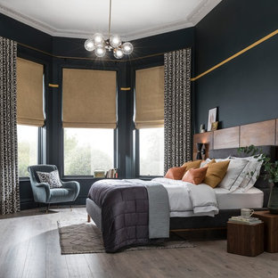 Medium sized contemporary master bedroom in West Midlands with blue walls, medium hardwood flooring and grey floors.