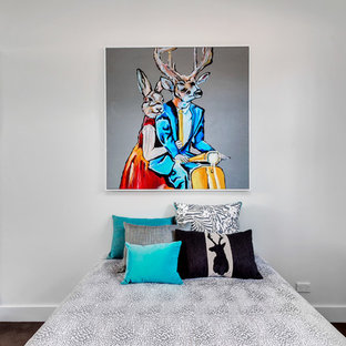 This is an example of a contemporary guest bedroom in Adelaide with white walls, dark hardwood floors and brown floor.
