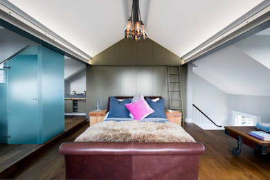 Diseño de dormitorio principal urbano grande con suelo de madera en tonos medios, paredes blancas y suelo marrón