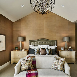Imagen de dormitorio principal, de estilo de casa de campo, grande, con paredes beige, moqueta, chimenea tradicional, marco de chimenea de piedra y suelo beige