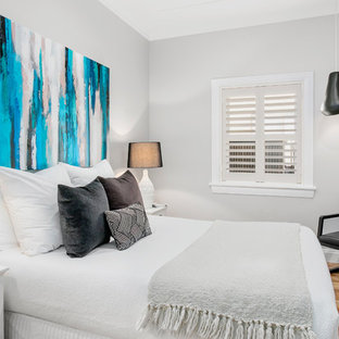 This is an example of a small contemporary guest bedroom in Sydney with grey walls, brown floor and medium hardwood floors.
