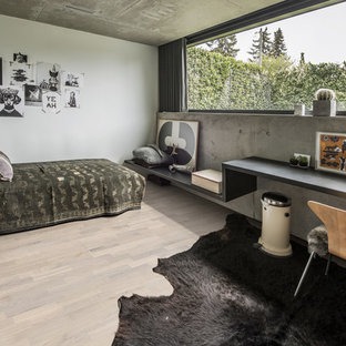 Medium sized urban guest bedroom with beige walls, light hardwood flooring, no fireplace and beige floors.