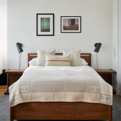 Inspiration for a contemporary medium tone wood floor and brown floor bedroom remodel in New York with white walls