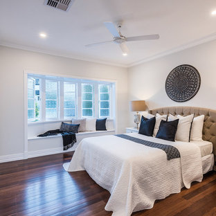 Beach style guest bedroom in Brisbane with white walls, dark hardwood floors and brown floor.