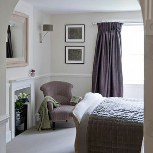 Imagen de dormitorio de estilo de casa de campo, de tamaño medio, sin chimenea, con paredes beige, moqueta y marco de chimenea de madera