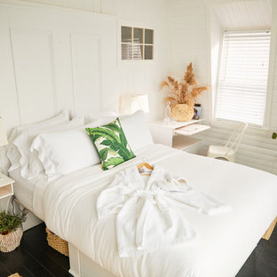 Modelo de dormitorio principal, exótico, de tamaño medio, con paredes blancas, suelo de madera pintada y suelo negro