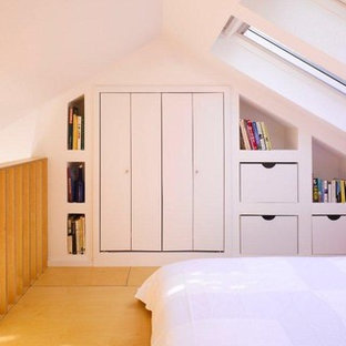 Modernes Schlafzimmer im Loft-Style mit weißer Wandfarbe und Sperrholzboden in Dublin