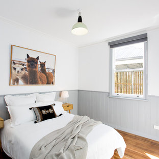 This is an example of a scandinavian bedroom in Other with white walls, medium hardwood floors and brown floor.