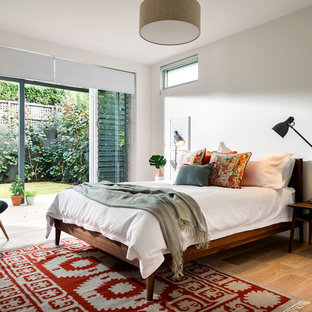 Immagine di una camera da letto moderna di medie dimensioni con pareti bianche e parquet chiaro
