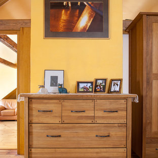 Foto de dormitorio principal, campestre, grande, con paredes amarillas y suelo de madera clara