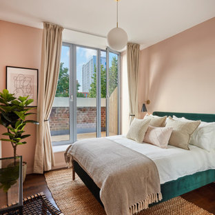 Foto de dormitorio contemporáneo con paredes rosas, suelo de madera oscura y suelo marrón