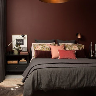 Modelo de dormitorio principal, bohemio, con paredes rojas y suelo de cemento
