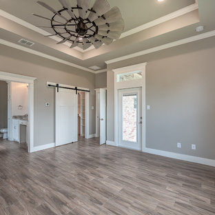 Photo of a mid-sized arts and crafts master bedroom in Other with grey walls, ceramic floors and brown floor.