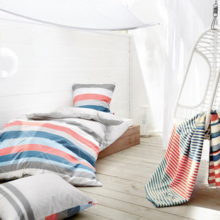 Kleines Maritimes Gästezimmer ohne Kamin mit weißer Wandfarbe, gebeiztem Holzboden und grauem Boden in Sonstige