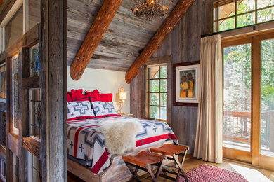 This is an example of a rustic loft bedroom in Denver with white walls and medium hardwood flooring.