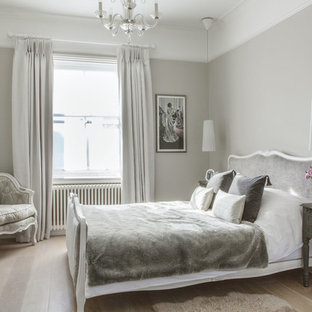Réalisation d'une chambre parentale victorienne avec un mur gris et un sol en bois clair.
