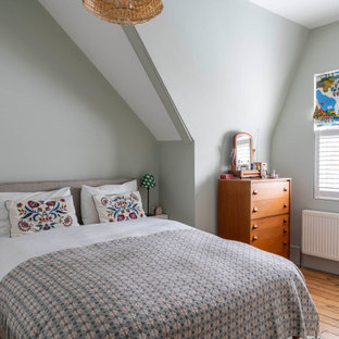 Design ideas for a scandinavian bedroom in London with green walls, medium hardwood flooring and brown floors.