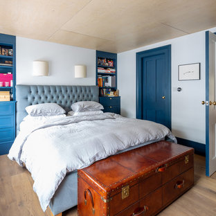 Foto de dormitorio clásico renovado, sin chimenea, con paredes azules y suelo de madera clara