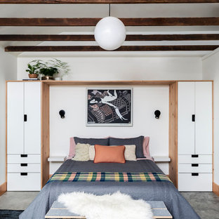Modelo de habitación de invitados contemporánea, pequeña, con paredes blancas, suelo de cemento y suelo gris
