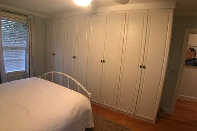 Ejemplo de dormitorio principal clásico grande con suelo de madera en tonos medios y suelo marrón