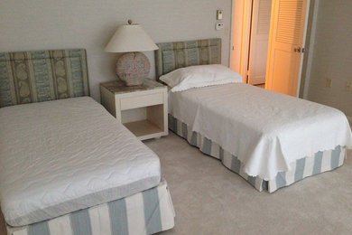 マイアミにある中くらいなビーチスタイルのおしゃれな客用寝室 (グレーの壁、カーペット敷き、暖炉なし、ベージュの床) のインテリア