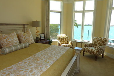 タンパにある広いトランジショナルスタイルのおしゃれな主寝室 (黄色い壁、カーペット敷き)