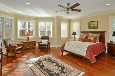 Diseño de habitación de invitados clásica grande sin chimenea con paredes beige, suelo de madera clara y suelo marrón