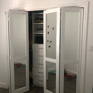 Imagen de habitación de invitados moderna, de tamaño medio, sin chimenea, con paredes blancas, suelo laminado y suelo marrón