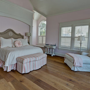 Idee per una camera matrimoniale american style di medie dimensioni con pavimento in legno massello medio, pareti rosa, nessun camino e pavimento marrone