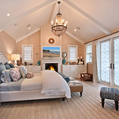 Example of a classic bedroom design in Orange County with beige walls and a standard fireplace