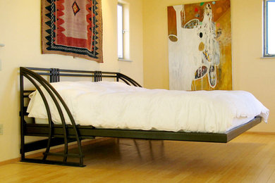 カンザスシティにある中くらいなサンタフェスタイルのおしゃれな客用寝室 (ベージュの壁、淡色無垢フローリング、ベージュの床)