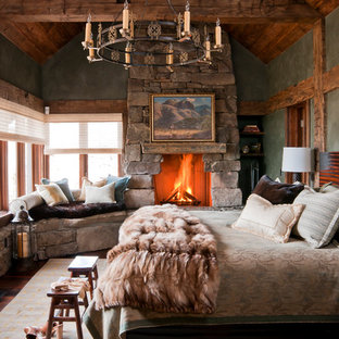 Foto de habitación de invitados rural con chimenea tradicional, marco de chimenea de piedra, paredes verdes y moqueta