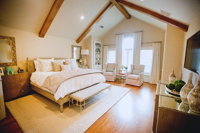Modelo de dormitorio principal tradicional con paredes blancas y suelo de madera en tonos medios
