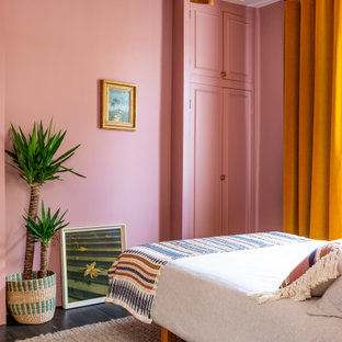 Exemple d'une chambre d'amis éclectique de taille moyenne avec un mur rose, un sol en bois foncé, aucune cheminée et un sol marron.